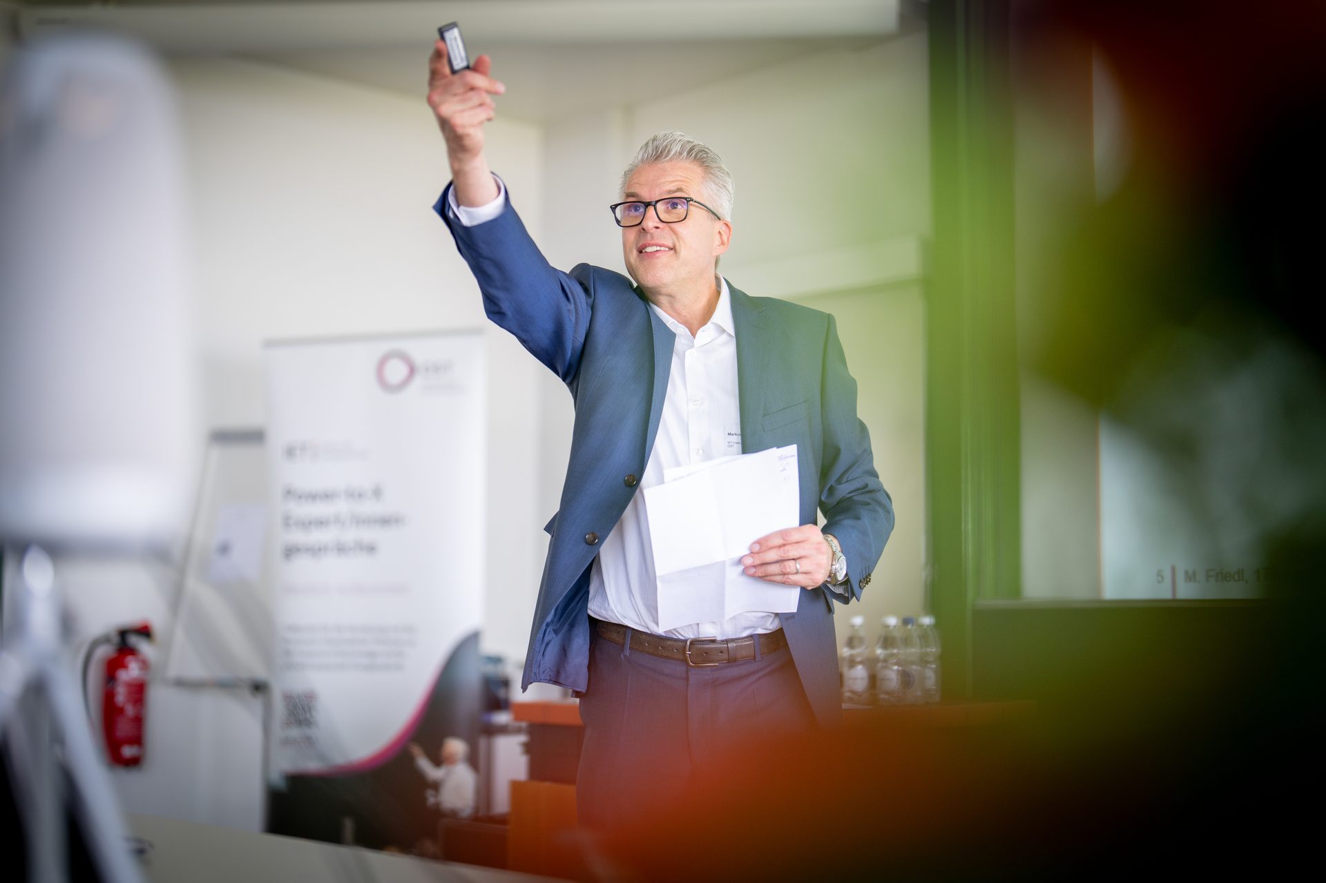 Referent hebt Abstimmungsklicker beim Vortrag – Eventfotografie OST PTX 2026, kordial